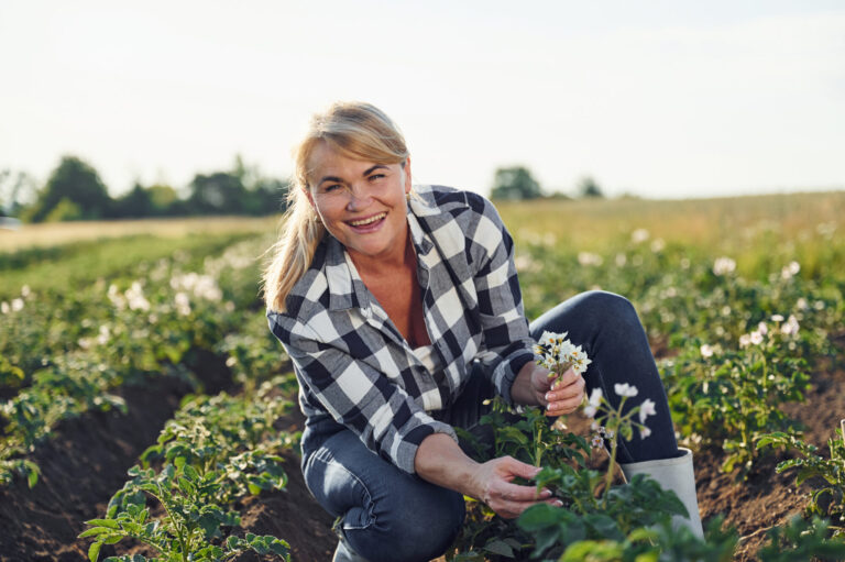 Woman is on the agricultural field at daytime.