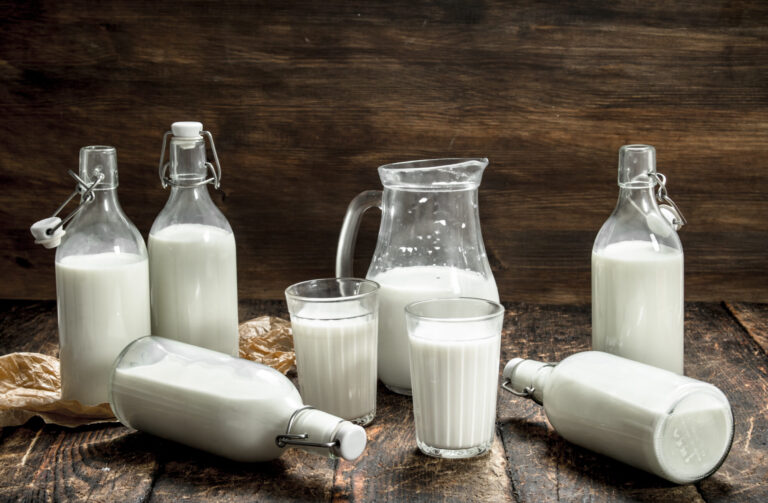 Fresh cow's milk. On a wooden background.