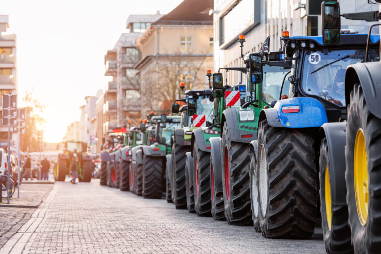 Farmers union protest strike against government Policy in Germany Europe. Tractors vehicles blocks city road traffic. Agriculture farm machines Magdeburg central Domplatz square.
